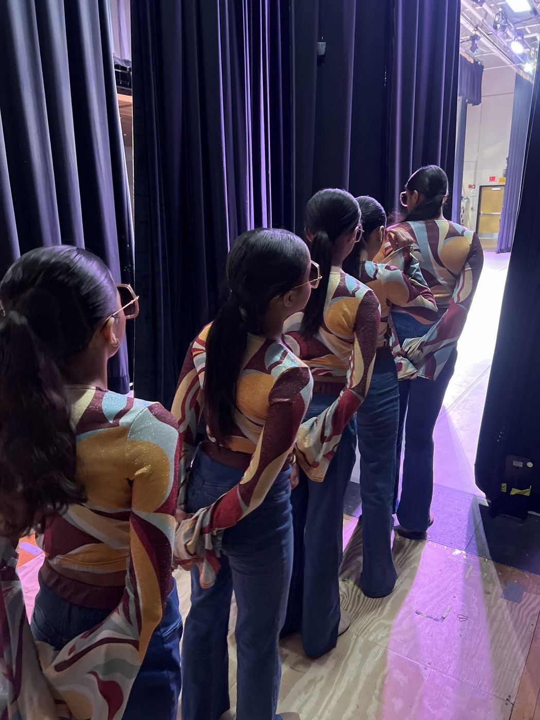 Dancers in retro costumes lined up in the wings
