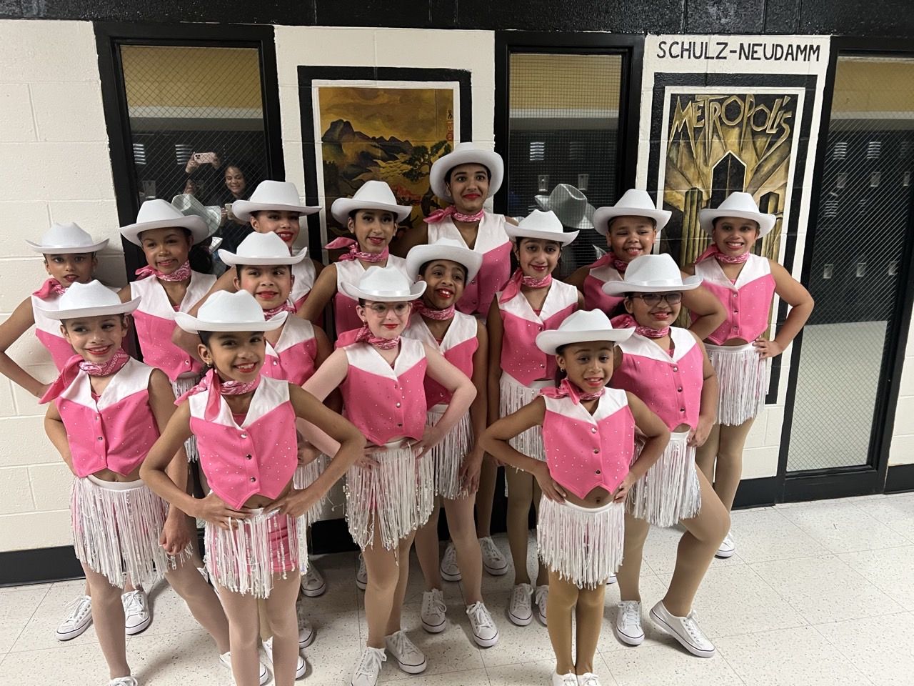 Dancers in western costumes and cowboy hats backstage