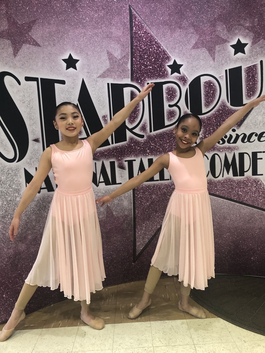 Two ADS dancers in pink lyrical costumes posing at a national dance competition
