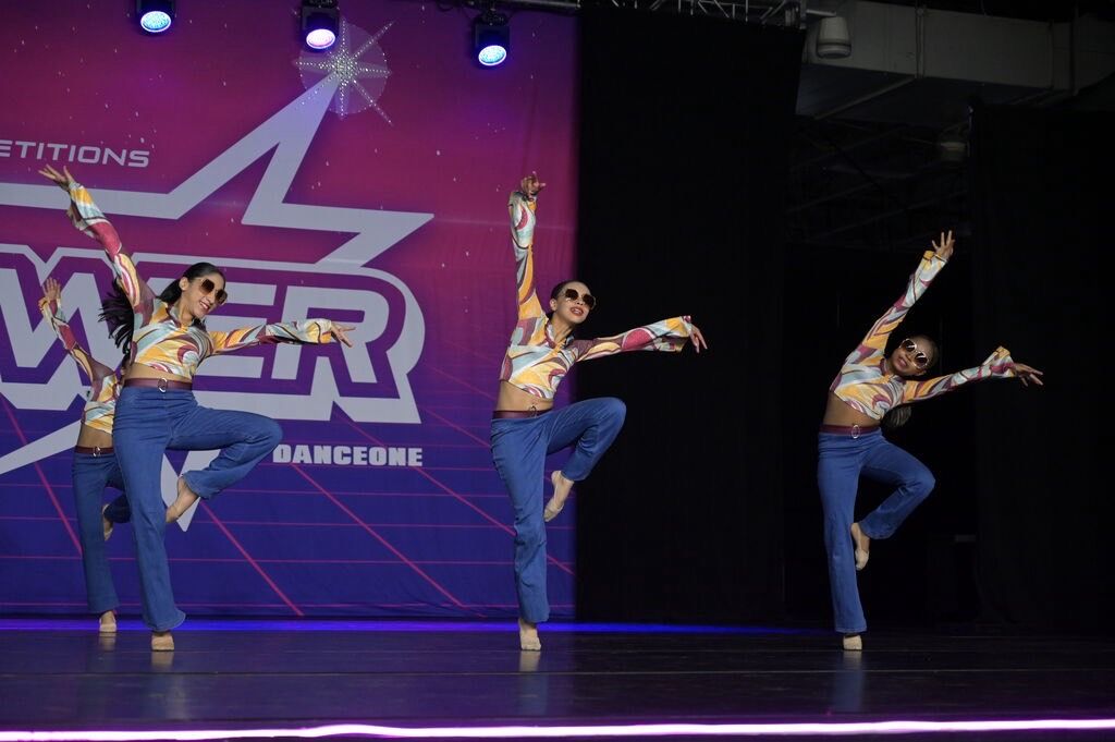 Jazz dancers in retro costumes and sunglasses performing on stage