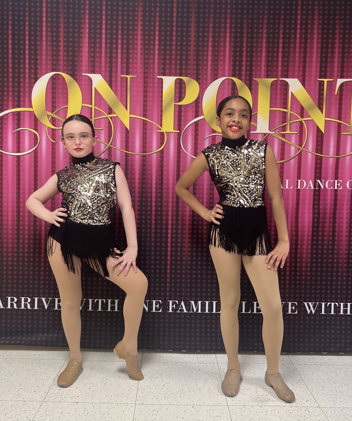 Two dancers in black and gold sequined costumes