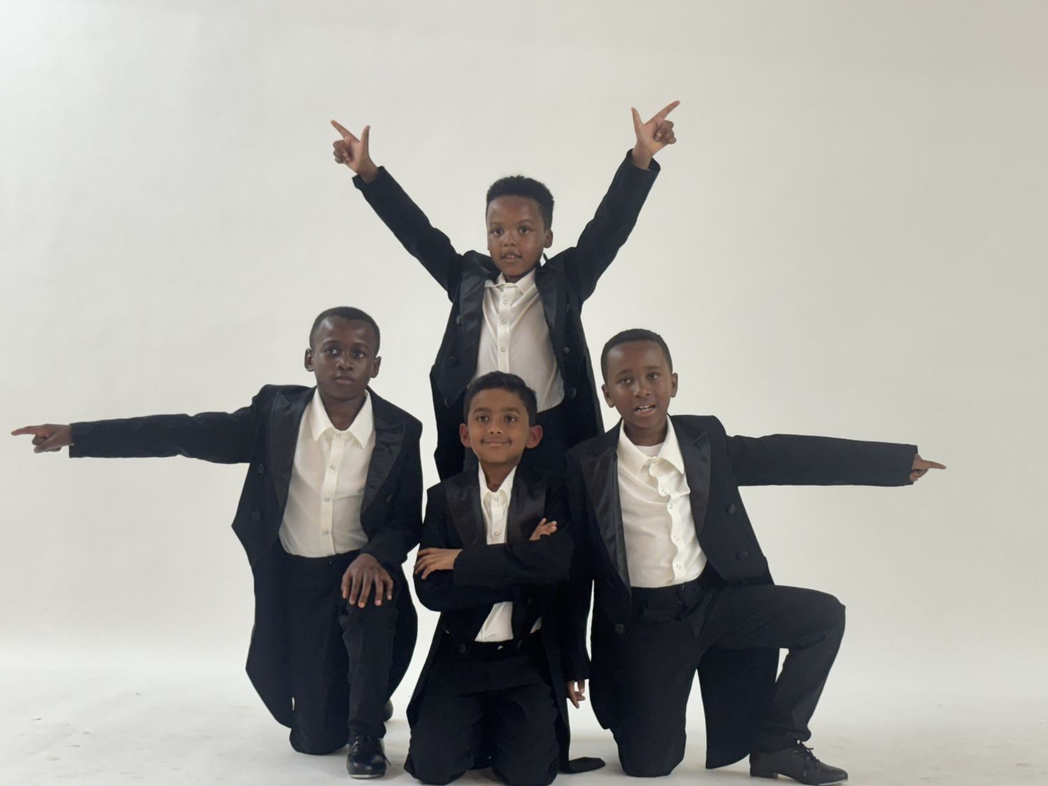 Four boys in tailcoat tuxedos posing for their glamour photo
