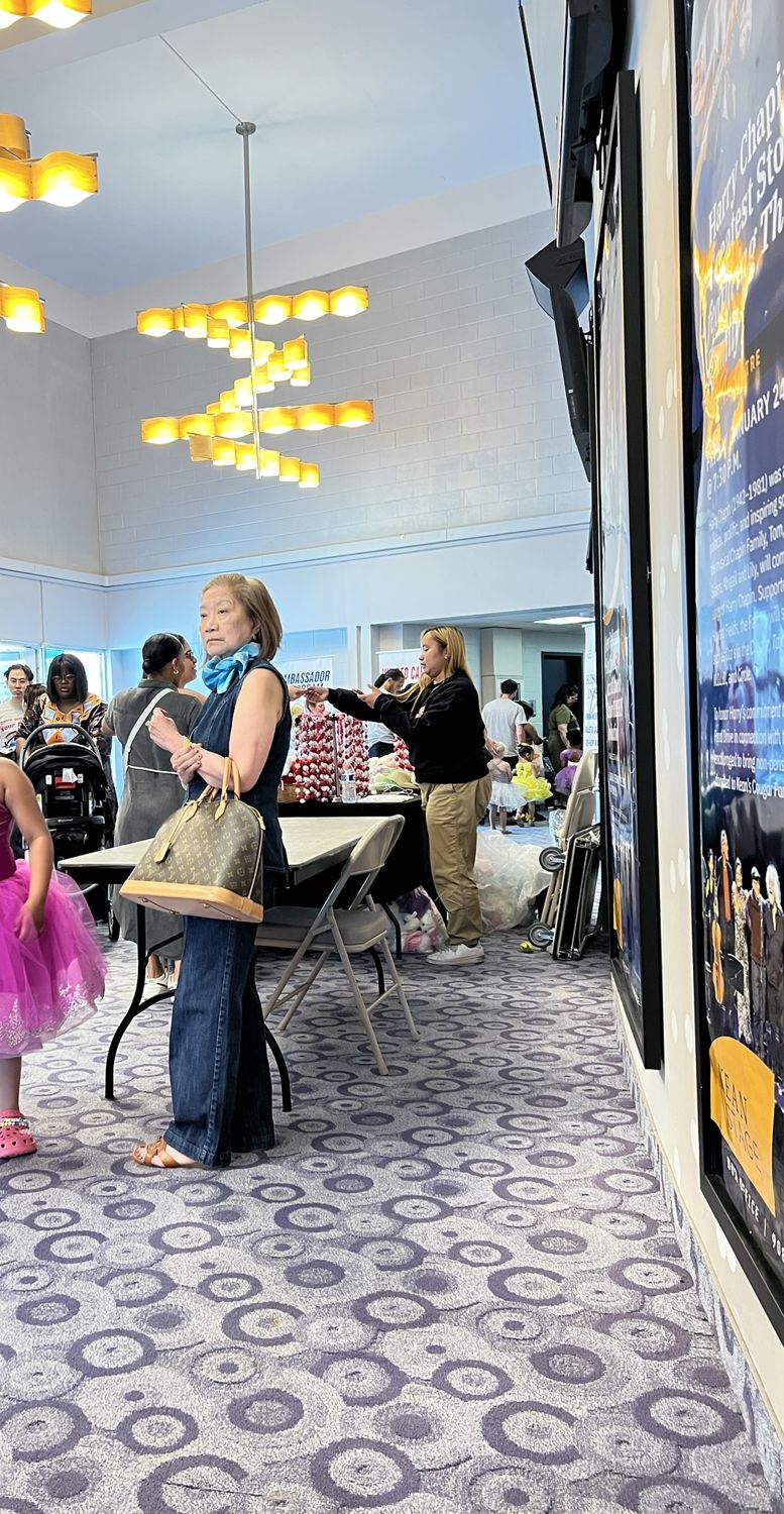 Families gathering in the theater lobby with flowers before the recital