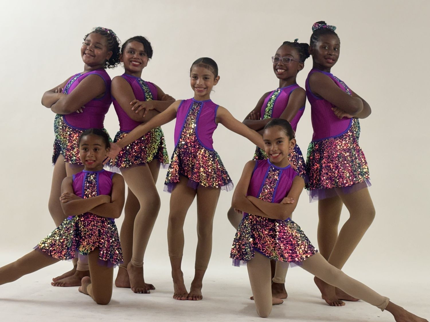 Jazz dancers in purple sequin costumes posing at the photo shoot