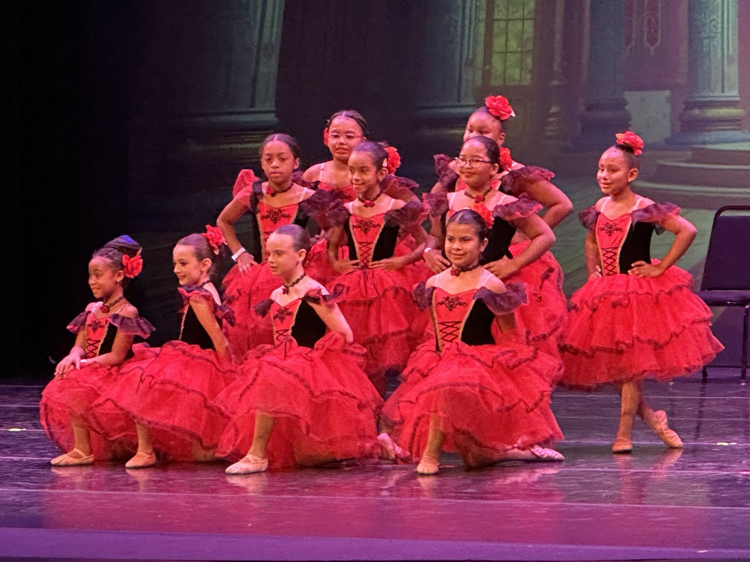 ADS ballet dancers in red and black Spanish-style tutus performing on stage at the year-end recital