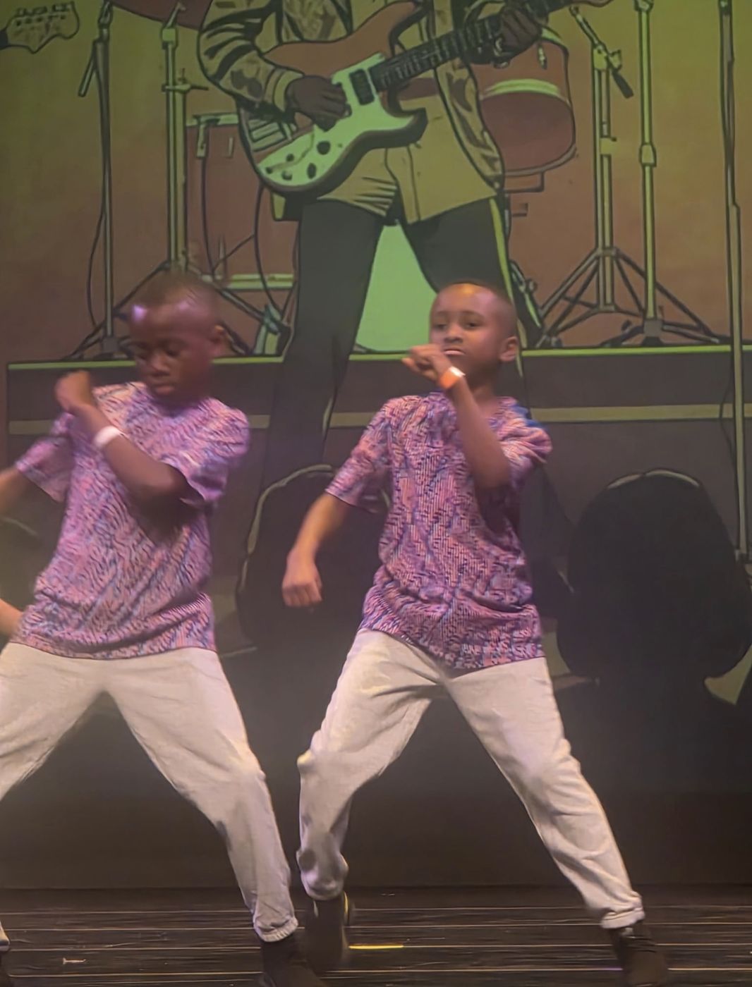 Two boys dancing a hip hop routine on stage