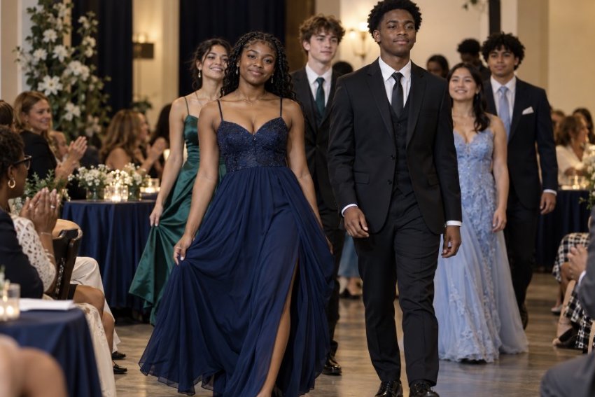Seniors in gowns and tuxedos walking the runway at the fashion show gala