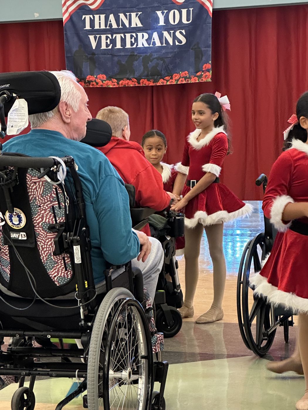 An ADS dancer holding a veteran's hand after the holiday performance